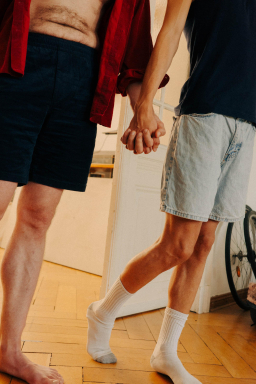 Schwules Paar laeuft Hand in Hand ins Schlafzimmer